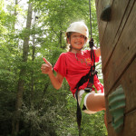 Girl giving thumbs up on rockclimbing course