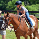 staff and camper on a sunny day at riding